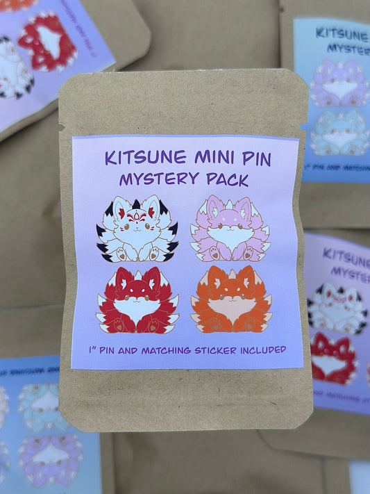 Packaging for Kitsune Mini Pin Mystery Pack showing various designs of fox face pins with matching stickers displayed behind them.