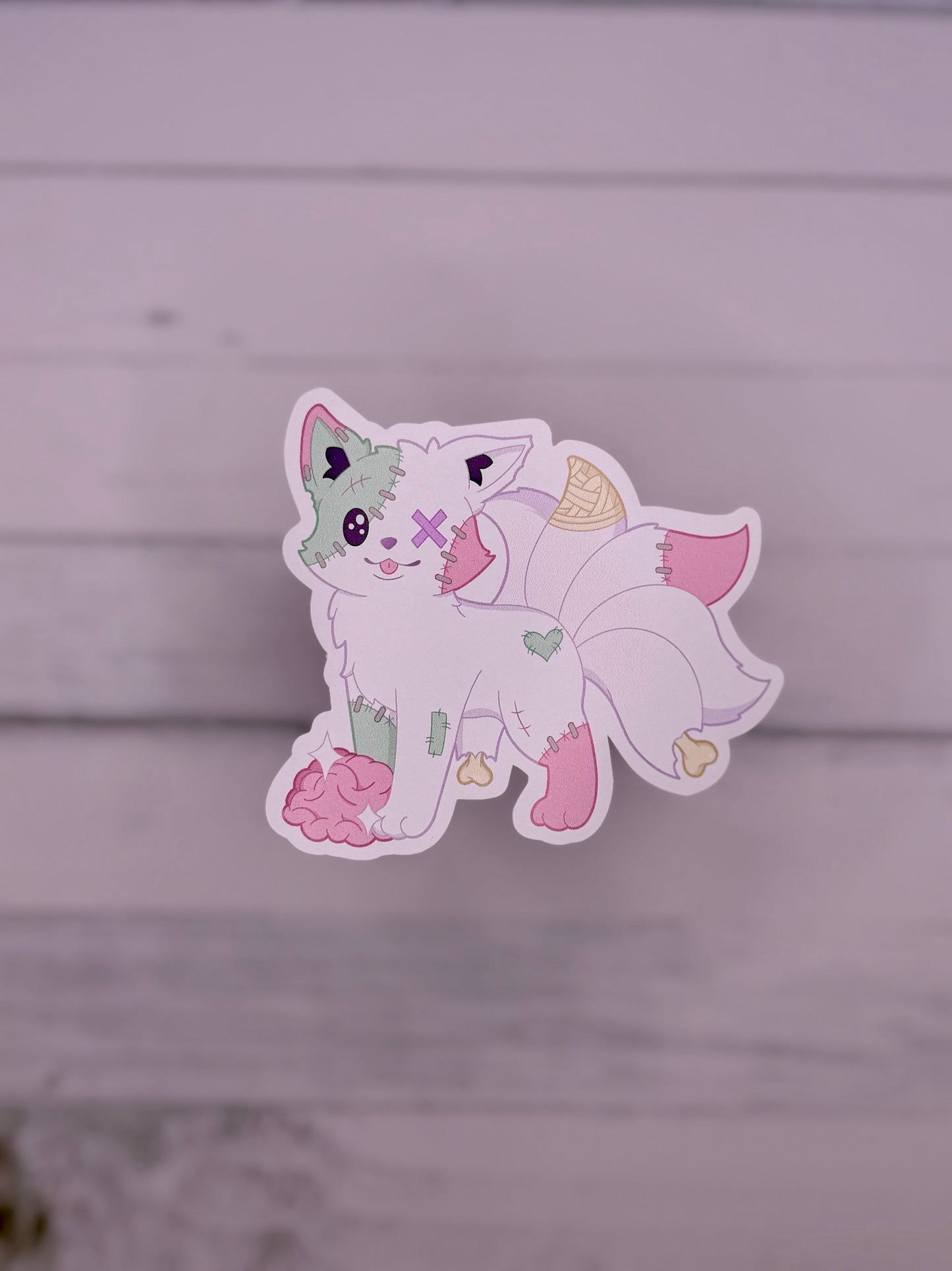 Pastel stitched kitsune sticker with patchwork details, exposed brain, and plush zombie inspired design