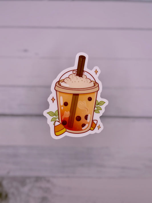 Cute Halloween themed bubble tea sticker featuring an orange milk tea with ghost shapes, boba pearls, whipped topping, cinnamon stick, candy corn, and sparkles