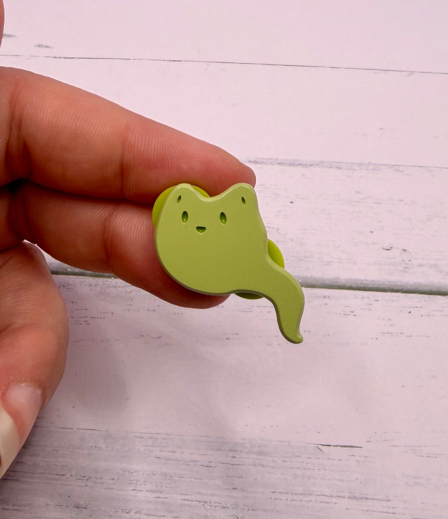 Green ghost fox enamel pin with a curved ghost tail