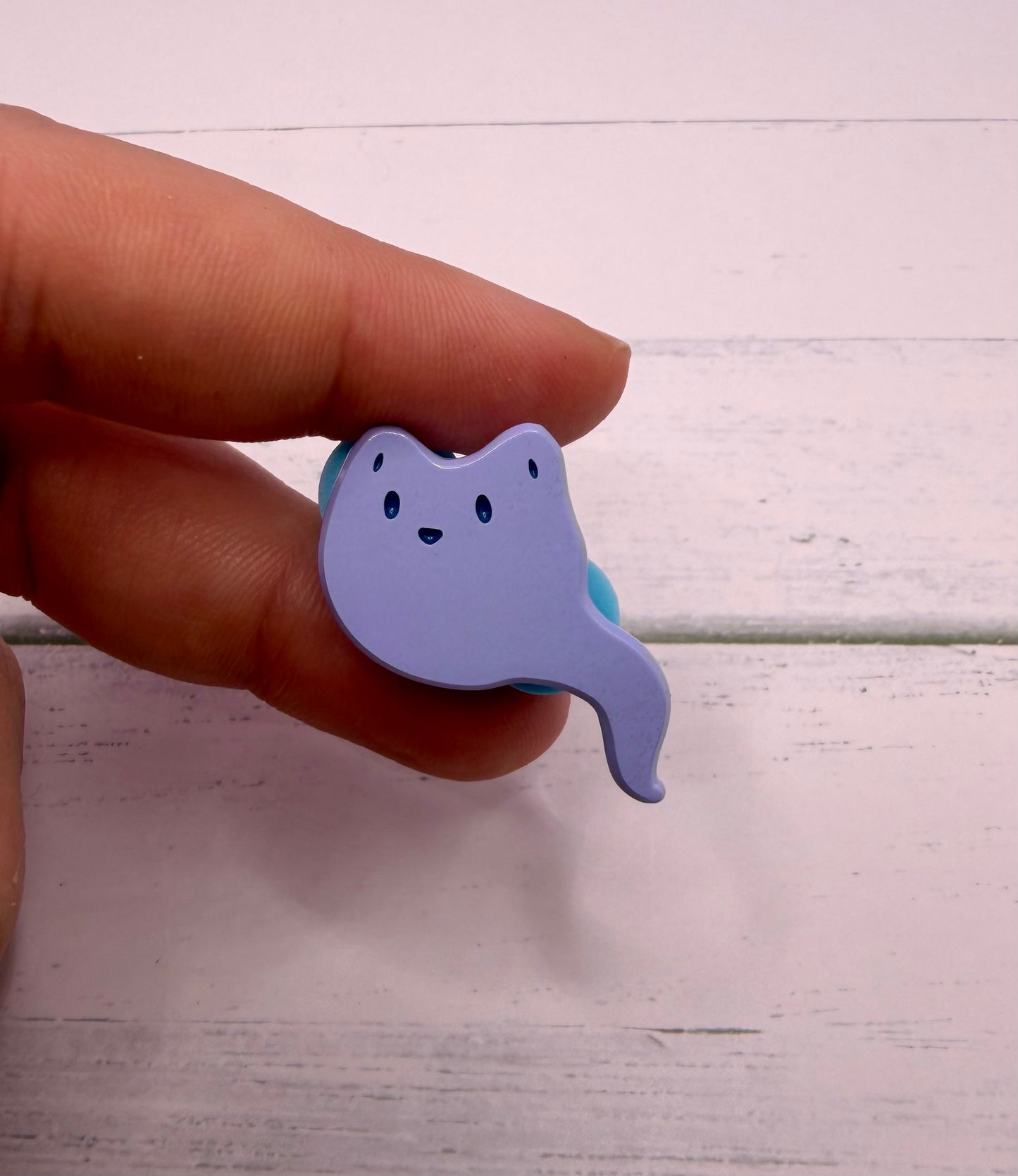 blue ghost fox enamel pin with a curved ghost tail